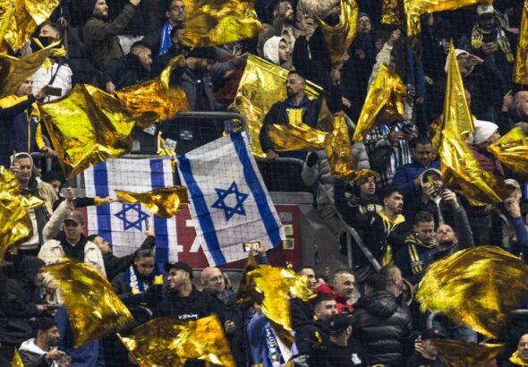 Torcedores do Maccabi agitam bandeiras amarelas ao lado de bandeiras israelenses durante a fase da Liga Europa da UEFA, em partida de futebol contra o Ajax Amsterdam. 07/11/2024 - (Robin van Lonkhuijs...